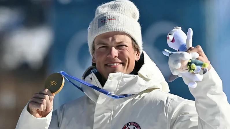 O norueguês Johannes Høsflot Klæbo celebra o ouro no pódio dos 10km livre com largada intervalada do esqui cross-country, no Estádio de Esqui Cross-Country de Tesero, nos Jogos Olímpicos de Inverno Milano Cortina 2026, em 13 de fevereiro de 2026. (Foto: Javier Soriano/AFP)