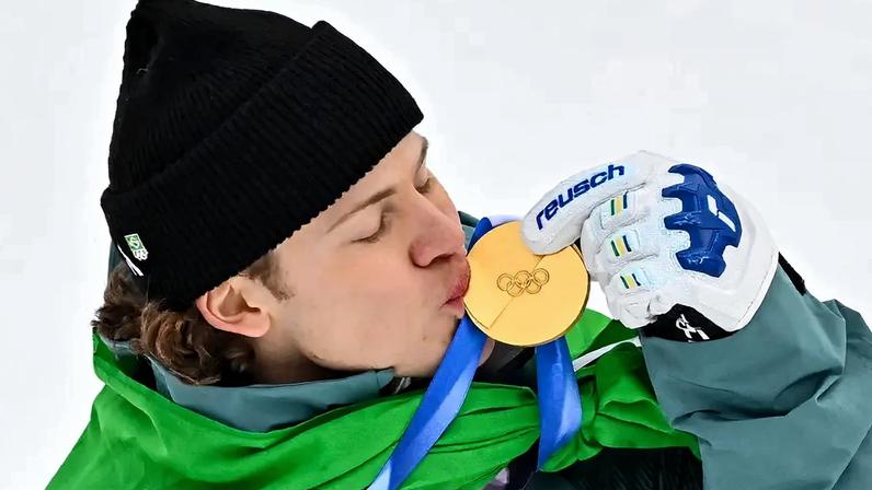 Lucas Pinheiro Braathen beija a medalha de ouro no pódio do slalom gigante masculino em 2026. (Foto: Fabrice Coffrini/AFP)