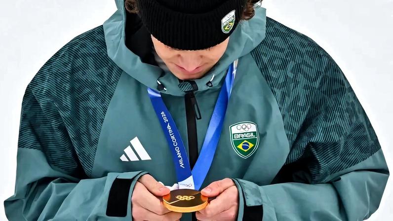 Lucas Pinheiro Braathen observa a medalha de ouro no pódio do slalom gigante masculino em 2026. (Foto: Fabrice Coffrini/AFP)