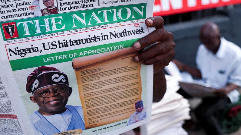 People read newspapers reporting on U.S. airstrikes against Islamic State militants in Nigeria, according to U.S. President Donald Trump and the U.S. military, in Lagos, Nigeria, December 26, 2025. REUTERS/Sodiq Adelakun/File Photo