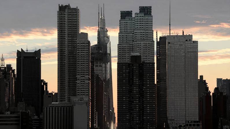 O sol nasce atrás do horizonte de Midtown Manhattan ao longo da 42ª Rua, na cidade de Nova York