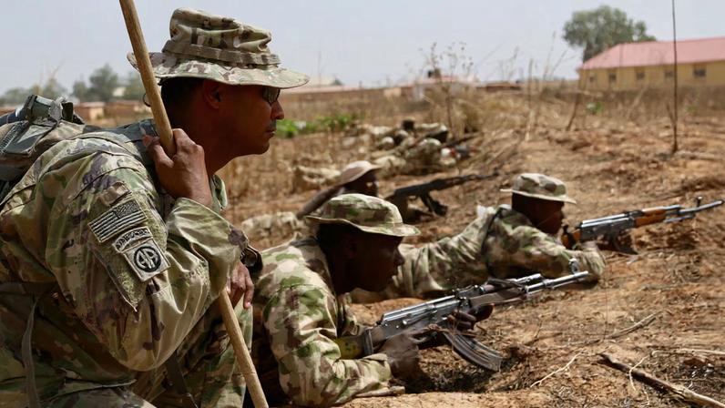A U.S. Army soldier (L) trains Nigerian Army soldiers at a military compound in Jaji, Nigeria