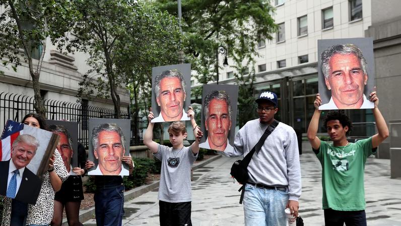 Demonstrators hold signs aloft protesting Jeffrey Epstein, as he awaits arraignment in the Southern District of New York on charges of sex trafficking of minors and conspiracy to commit sex trafficking of minors, in New York, U.S., July 8, 2019. REUTERS/Shannon Stapleton