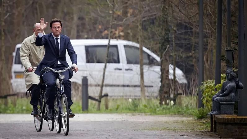 Dutch Prime Minister Mark Rutte and Stef Blok from the People's Party for Freedom and Democracy (VVD) arrive on their bicycles at Catshuis, the official residence of the Prime Minister, in the Hague, on March 29, 2012.