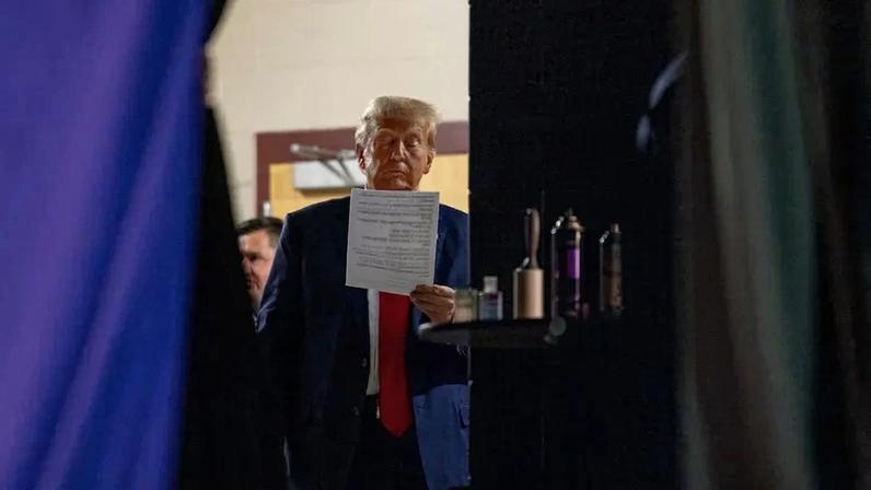 Republican presidential candidate former President Donald Trump reads a document backstage before after taking the stage on October 9, 2023 in Wolfeboro, New Hampshire.