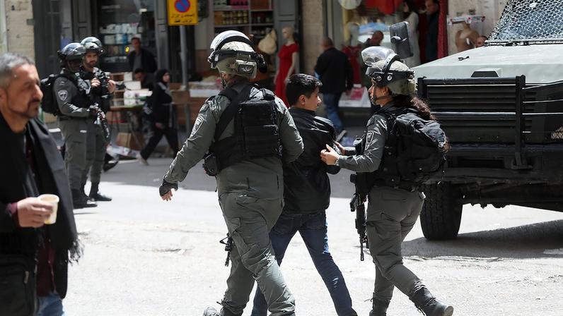 Israeli soldiers detain a Palestinian child during a raid in Hebron, West Bank, on April 16, 2025.