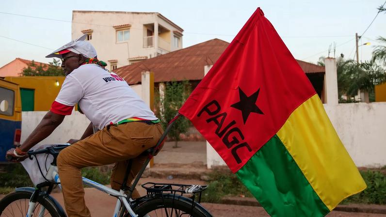 A supporter of presidential candidate Domingos Simoes Pereira rides a bicycle in Bissau
