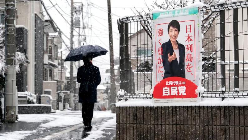 A pedestrian walks past an election poster bearing a photograph of Japanese Prime Minister Sanae Takaichi displayed near a polling station in Tokyo on Feb. 8.