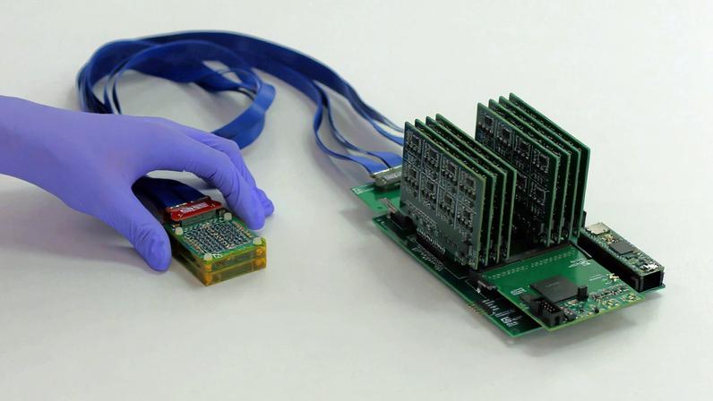 The complete setup shows, on left, the ultrasound prototype connected by wires to exposed circuit boards.