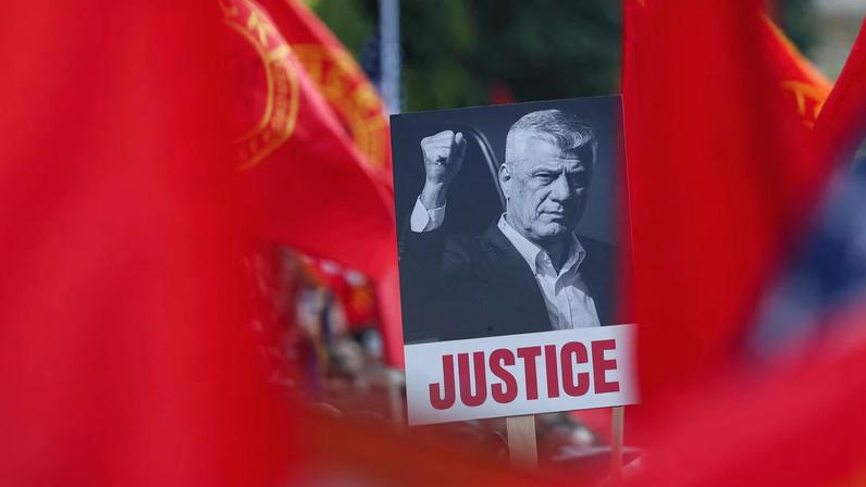 A banner depicting former Kosovo President Hashim Thaci is held, as demonstrators protest in support of former Kosovo President Hashim Thaci and other former Kosovo Liberation Army (KLA) members, who are on trial for war crimes at a court in the Netherlands, in Pristina
