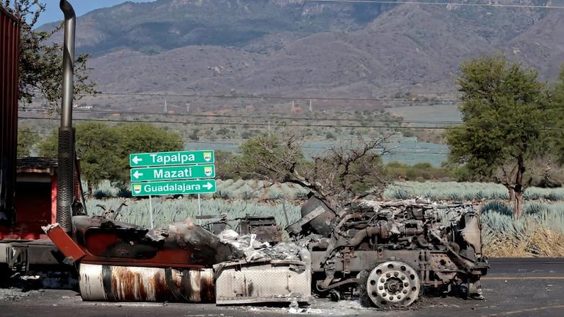 A burned truck sits on a road after waves of retaliatory cartel violence rocked Jalisco state following the death of a major drug kingpin, seen near Tapalpa, Mexico, on Feb. 24.