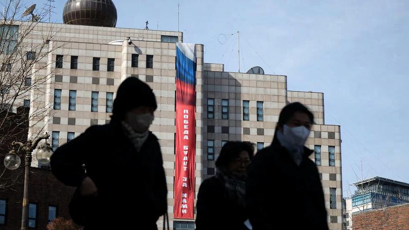 People walk past a banner that reads "Victory will be ours," hanging on the exterior of the Russian Embassy, ahead of the fourth anniversary of Russia’s invasion of Ukraine, in Seoul, South Korea, February 23, 2026.
