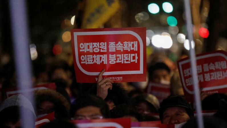 A doctor holds a slogan in a protest against a plan to admit more students to medical school, in front of the Presidential Office in Seoul, South Korea, February 22, 2024.