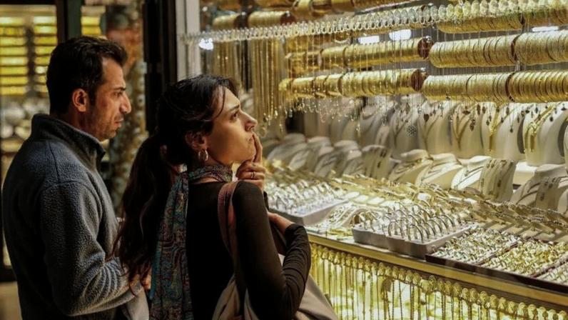 Pessoas olham para joias de ouro em uma joalheria no Grande Bazar em Istambul, Turquia