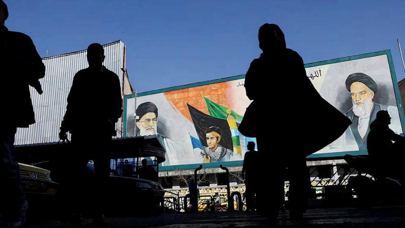People walk near a mural featuring images of Iran's Supreme Leader Ayatollah Ali Khamenei and leader of Iran's 1979 Islamic Revolution Ayatollah Ruhollah Khomeini, on a street in Tehran