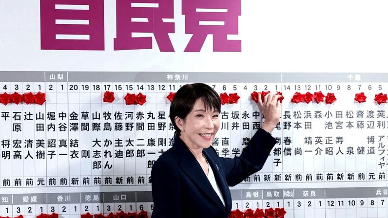 Japanese Prime Minister Sanae Takaichi, the leader of the ruling Liberal Democratic Party (LDP), places a red paper rose on the name of an elected candidate at the LDP headquarters in Tokyo on Feb. 8.