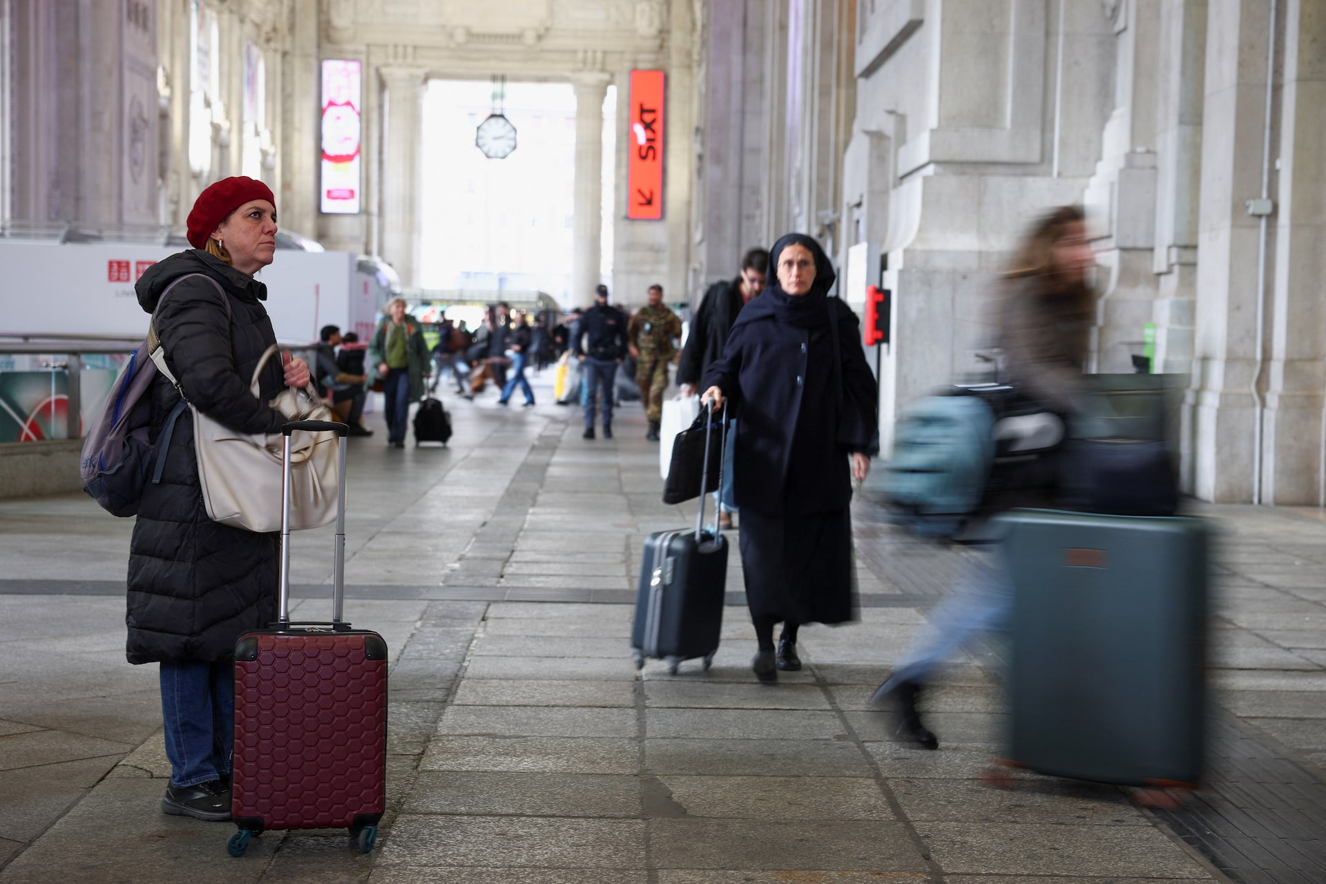 A woman looks at a board announcing delays at the Milan train station, as Italian police investigate possible sabotage to electricity cables near the city of Bologna that have caused delays to a large part of the national railway network, in Milan, Italy, February 7, 2026.