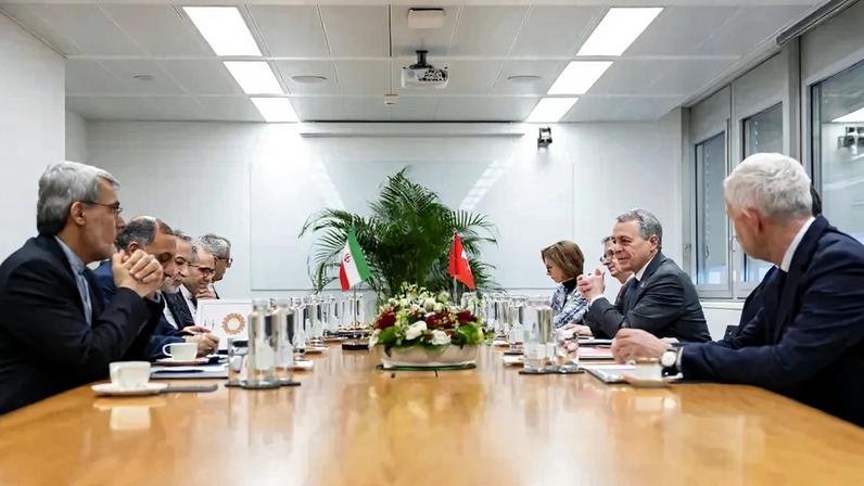 The Iranian and Swiss delegations sit on opposite sides of a table for indirect nuclear negotiations in Geneva.
