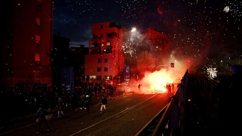 Manifestantes encapuzados lançam sinalizadores contra a polícia ao fim de protesto em Milão