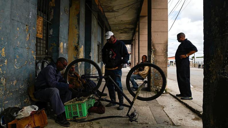 A man fixes a bicycle as Cubans brace for fuel scarcity measures after U.S. tightens oil supply blockade, in Havana, Cuba, February 6, 2026. REUTERS/Norlys Perez