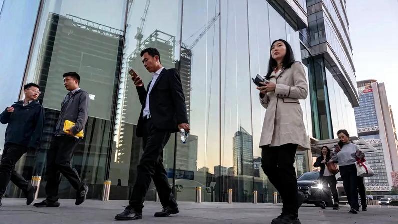 Employees leave their office towers at the end of the workday in Beijing.