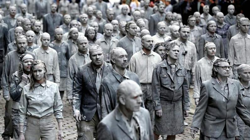 Performance artists covered in clay to look like zombies walk trance-like through the city center in Hamburg, Germany on July 5, 2017.