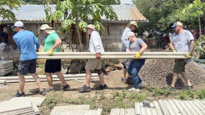 Volunteers from Abilene, Texas, carry a column that will support prefabricated wall panels at the Project Nehemiah construction site in Montepeque. From left are Daniel Wright, Darren Crider, John Wheeler and Laynette Wright.