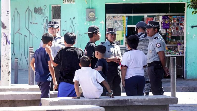 Policiais conversam com crianças um dia depois de um ataque armado em um playground em San Francisco del Rincon, estado de Guanajuato, no México. Créditos: MARIO ARMAS / AFP