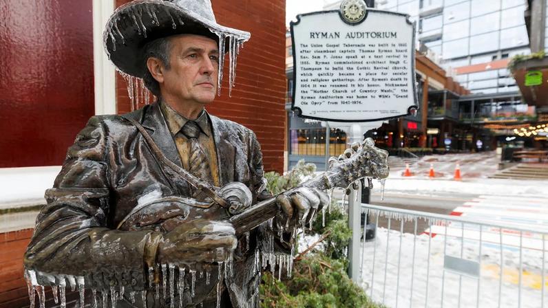 A statue of Bill Monroe outside the Ryman Auditorium stands covered in ice following a historic storm that cut off power to clubs and musicians around Nashville.