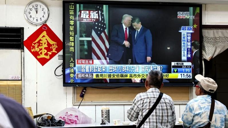 People watch a news program showing a meeting between U.S. President Donald Trump and Chinese President Xi Jinping in South Korea, seen in Taipei on Oct. 30, 2025.