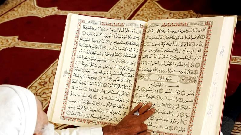 Fotografia de um homem iemenita lê o Alcorão Sagrado durante o mês sagrado do Ramadã na histórica Mesquita Al-Kabir.