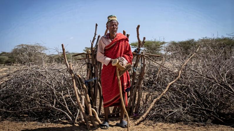 A Turkana elder stands in front of a boma in the settlement of Kapese. Image by Christopher Clark for Mongabay.