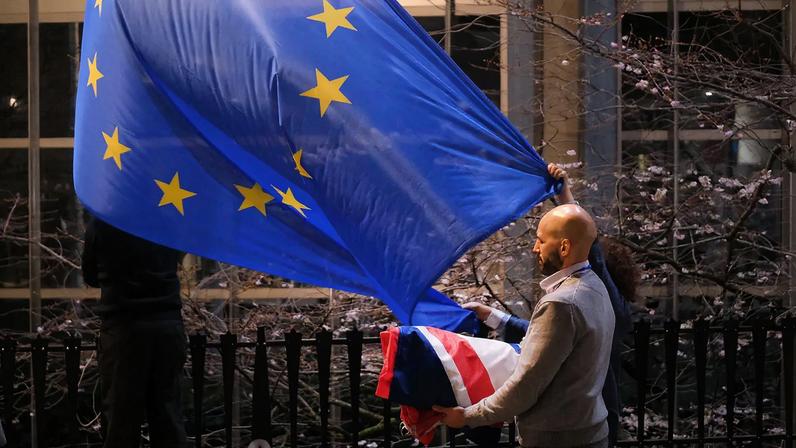 European Parliament workers replace the British flag with the EU flag outside the European Parliament in Brussels on Jan. 31, 2020.