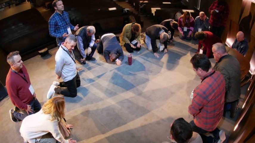 Ministers, including Chris Seidman (in red), Rick Atchley, Josh Ross and Evertt Hufard, pray during a connection time at ReMission.