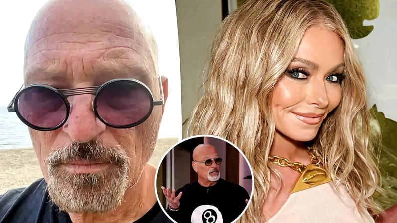 Howie Mandel in sunglasses and a black t-shirt, taking a selfie at a beach.