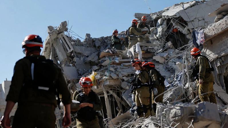 Equipe de resgate trabalha no local do impacto após um ataque de mísseis do Irã contra Israel, em Rishon LeZion, Israel, em 14 de junho de 2025.