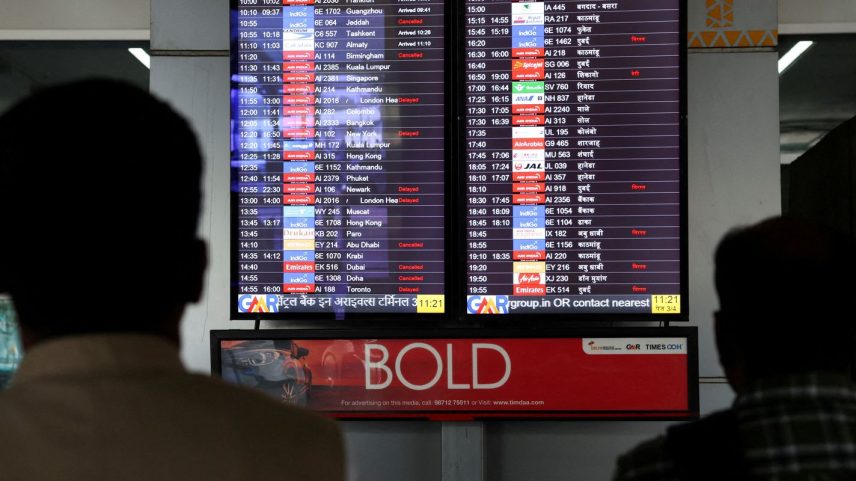 Pessoas observam tela com informações de voos no Aeroporto Internacional Indira Gandhi, em Nova Délhi, Índia 3 de março de 2026 REUTERS/Bhawika Chhabra