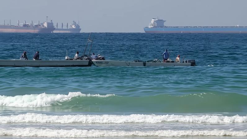 Fishing boats at work with tankers in the distance south of the strait of Hormuz off the port of Ras Al Khaimah in the United Arab Emirates.