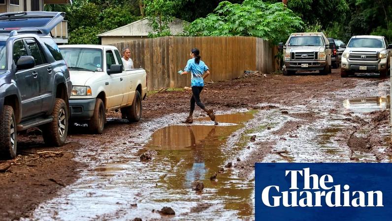 A young girl jumps over thick mud and water after flooding devastated the Otake Camp community in Waialua, Hawaii, on Sunday.