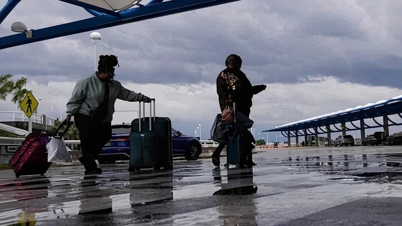 Passengers arrive under the threat of a fast approaching storm front at Jacksonville airport in Florida on Monday.
