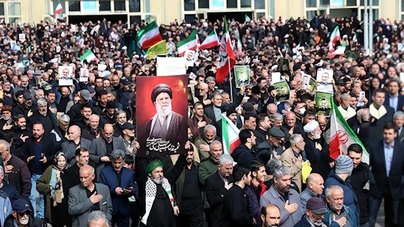 Un hombre sostiene un cartel del difunto líder supremo iraní, el ayatolá Alí Jamenei, en la ceremonia fúnebre del ex portavoz del Cuerpo de la Guardia Revolucionaria Islámica (IRGC), Alí Mohammad Naini, este sábado en Teherán.