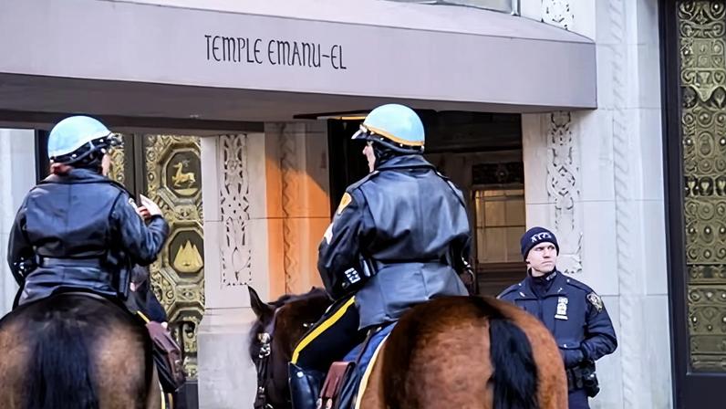 NYPD officers stand guard outside of Temple Emanu-El in February 2026 in New York.
