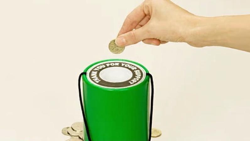 Hand putting coin into donation box