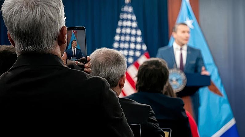 A member of the media records as Pete Hegseth speaks during a news conference at the Pentagon on Monday, 2 March 2026.