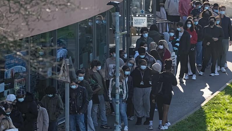 Students wearing face masks queue up to get vaccinated at the University of Kent in Canterbury.