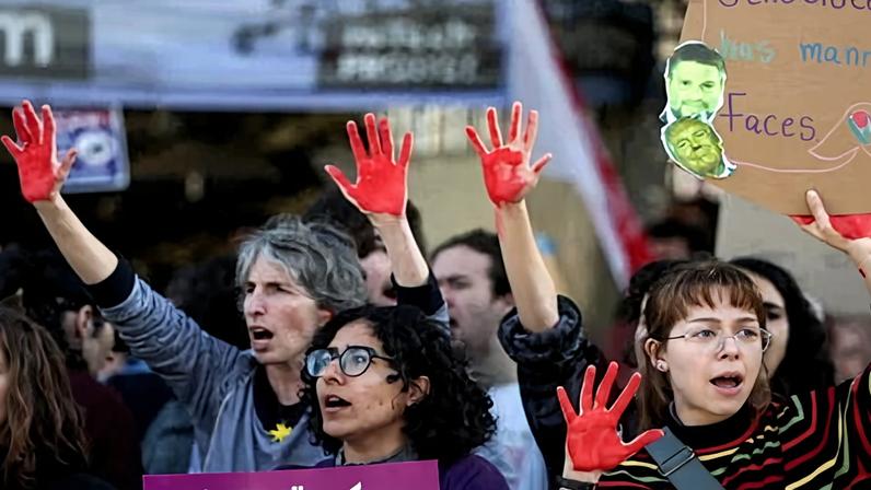 Demonstrators raise their hands covered in red paint during a protest near the Knesset after Israel's parliament passed the death penalty law on Monday.