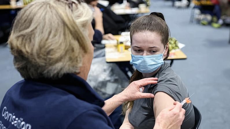 NHS staff administer a meningitis B vaccination at the University of Kent campus.