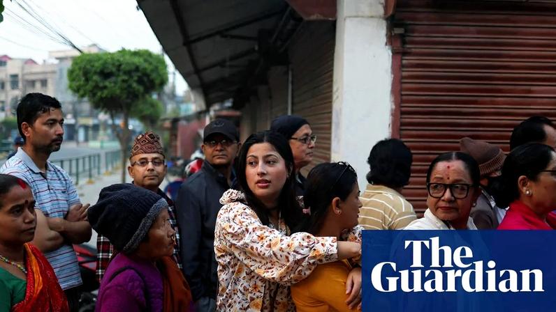 People stand in queues to vote outside a polling station during the general election in Nepal.