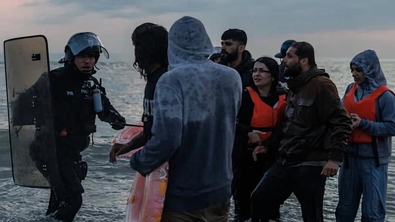 A police officer tries to stop people boarding small boats in Gravelines, northern France. A UK-French deal on unauthorised migration will expire on Tuesday.