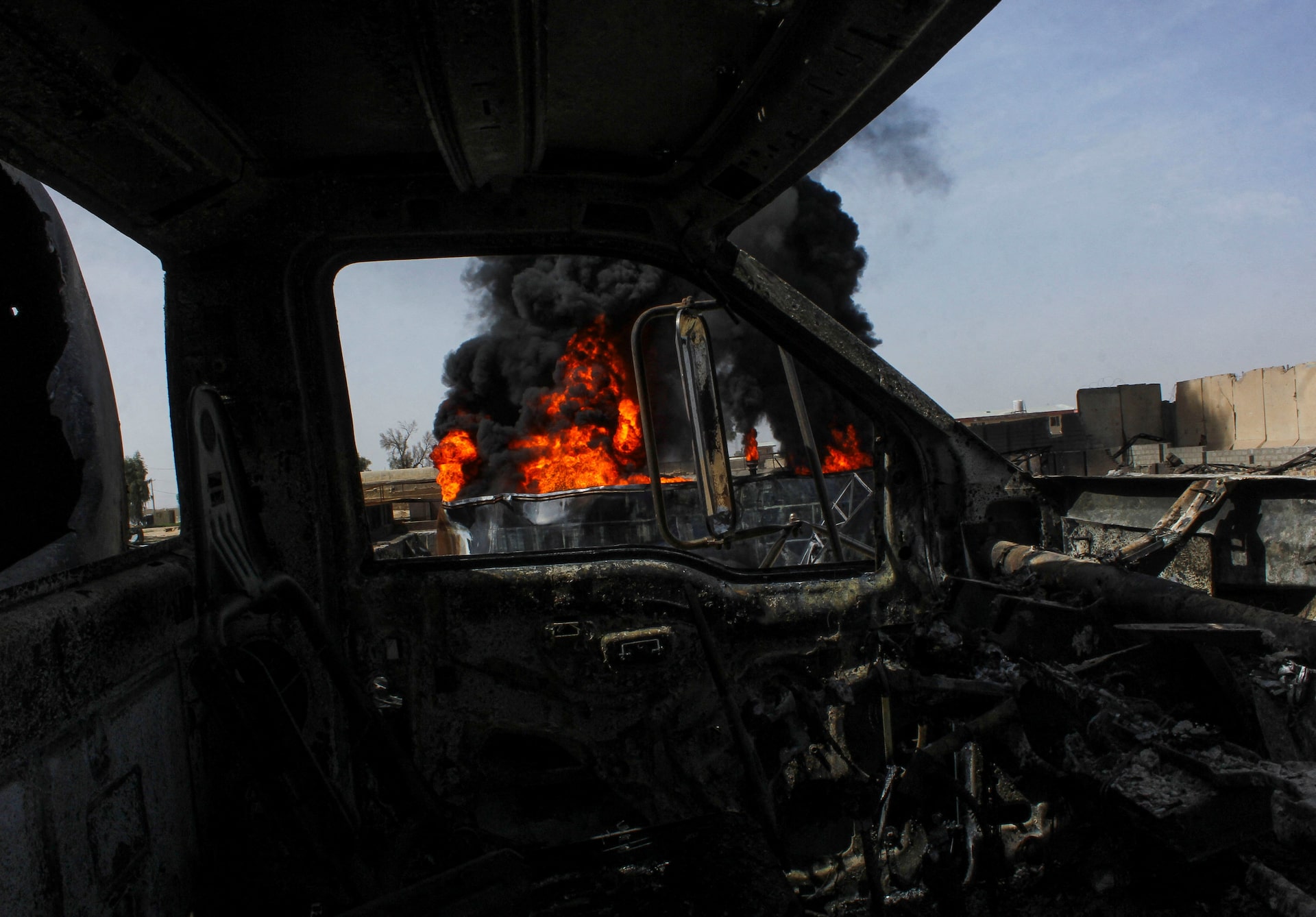 Thick black smoke is seen through a destroyed truck at private airline Kam Air's fuel depot after a strike in what the Taliban said was a Pakistani air strike, in Kandahar, Afghanistan, March 13, 2026.
